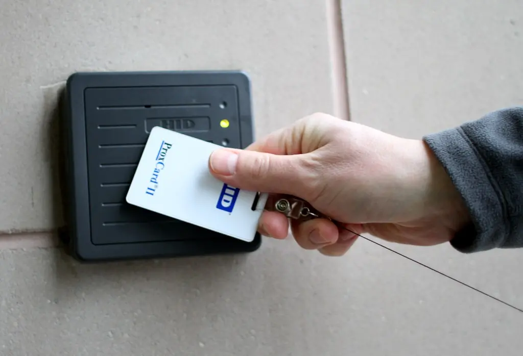 Worker presenting an access badge to a card reader, an access control measure used on secured sites