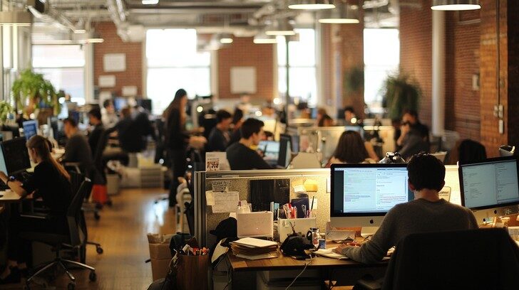 Busy open-plan corporate office, the kind of workplace where trade secrets and client data are exposed to corporate espionage and insider theft