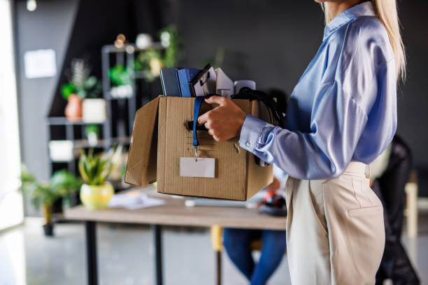 Departing employee leaving the office with a box of belongings, the offboarding moment an insider threat program is built to secure